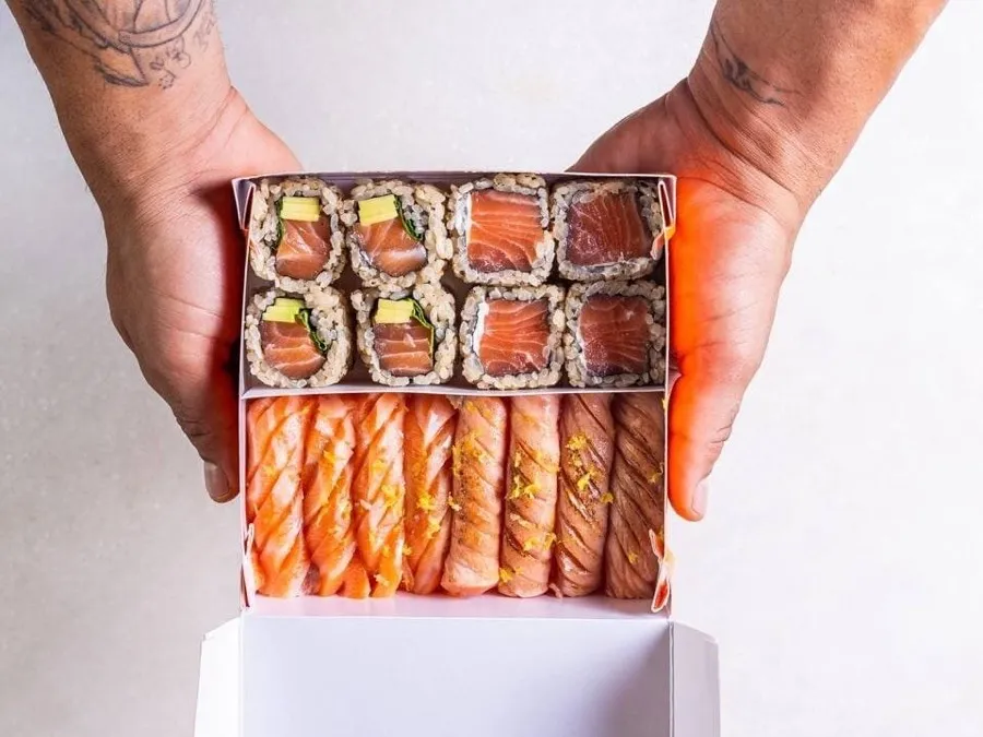 Caixa do Nemo com uramakis e niguiris de salmão, nas mãos do sushiman